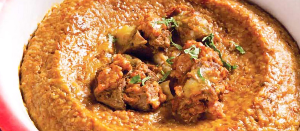 Close-up of spiced rice mixed with chopped vegetables and garnished with fresh herbs and green onion slices.